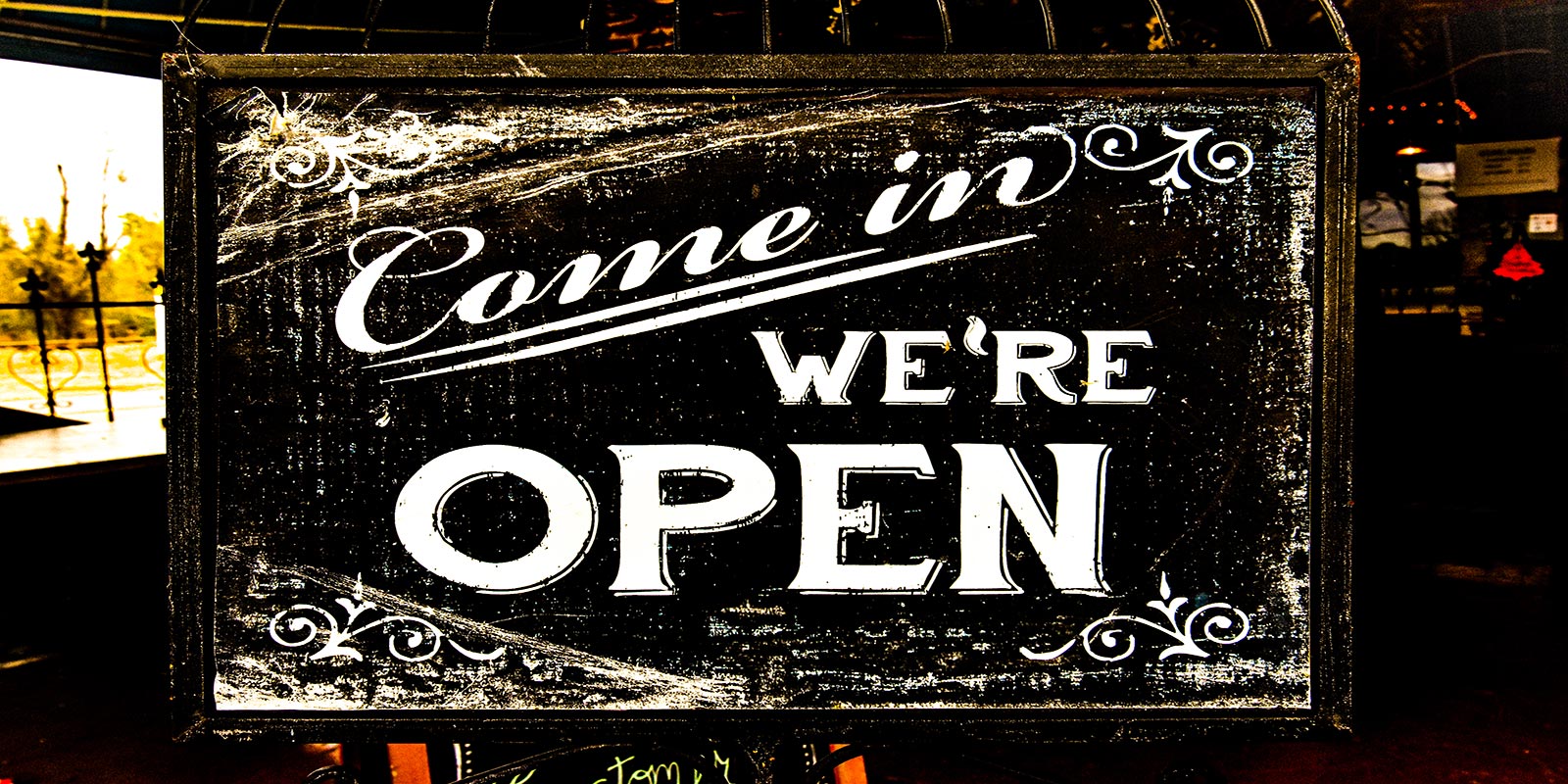 “Come in — We’re Open”: a chalkboard sign in a shop doorway in Smackover, Arkansas
